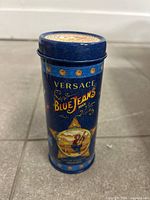 Front view of Versace Blue Jeans Man blue cylindrical tin