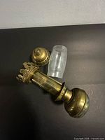 Full view of brass sconce components and glass shade