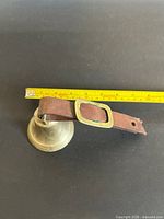 Bell with strap and tape measure indicating size