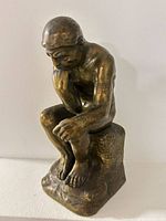 Front three-quarter view of bronze The Thinker figurine