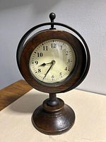 Front view showing dial, wood case, metal ring, base