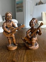 Front view of both carved wood musician figurines