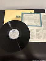 Vinyl record with centre label, sleeve, and liner insert visible