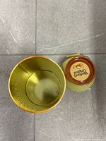 Open tin showing empty interior and detached lid