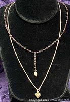 Front view of both necklaces on display bust