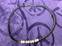 Full necklace view on purple fabric background