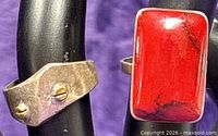 Close-up of both rings showing red coral stone and brass accented ring