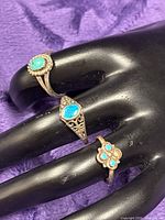 Three sterling silver rings on mannequin hand showing overall lot