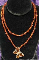 Front view of amber chip necklace with butterfly pendant