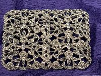 Front view of rectangular sterling silver filigree brooch with marcasite stones