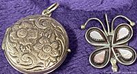 Round engraved sterling locket and butterfly pendant front view