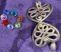 Open heart locket pendant with seven loose round stones