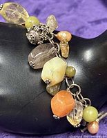 Close-up of multi-colored stone charms and sterling chain