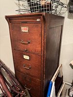 Full view of oak 4-drawer filing cabinet with brass pulls