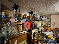 Shelved barware: mugs, steins, tumblers, shot glasses, vases