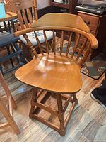 Front view showing spindle back, arms, contoured seat