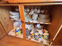 Cupboard shelf with floral platters, teacups, plates, bowls and geometric patterned pieces