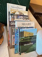 Front view of stack showing nine hardcover books with dust jackets, several titles visible