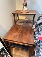 two nesting veneer side tables stacked together showing tops and legs