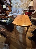 Table with both leaves dropped, showing rectangular center and turned legs, surrounding items for scale