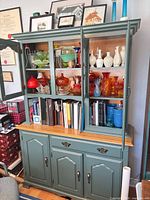 Overall view of two-piece hutch with glassware and books