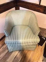 Front view of striped barrel-back armchair showing upholstery pattern and shape