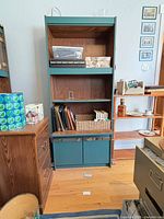 Full view of tall teal shelving unit with lower cabinet