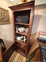 Full view of wood curio cabinet with contents on upper shelves