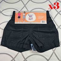 Black pair of shorts with branded card insert, size marking 4/5 visible