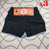 Front view showing black shorts on top with product sleeve