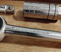 Close-up of ratchet handle stamped “TECOMASTER PROFESSIONAL” with adjoining extension and socket