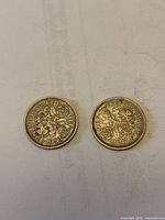 Reverse sides of both sixpence coins showing crowned rose design and dates 1953 and 1954