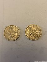 Reverse sides of both sixpence coins showing floral design and dates 1961, 1966