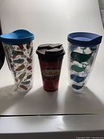 Front view of all three tumblers: flip-flop Tervis, Tim Hortons cup, whale Tervis