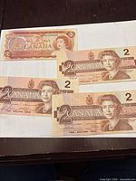 Obverse of four $2 Canadian banknotes, three 1986 series, one 1974 series