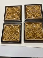 Front view of four matching floral majolica tiles
