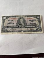 Obverse side of 1937 $10 note showing King George VI portrait, serial number 9509441, signatures, denomination