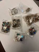 Multiple bags of assorted studs spread on table