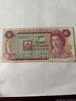 Front of 1970 Bermuda $5 note showing portrait, coat of arms, serial number 7013373