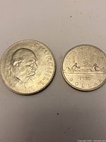 Reverse of 1965 Churchill crown and reverse of 1980 Canada Voyageur dollar