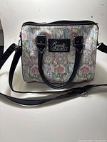 Front of handbag showing stained glass Beauty and the Beast print, handles and shoulder strap