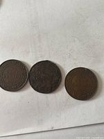 Reverse view of three Canadian one-cent coins showing dates 1920, 1894, 1920