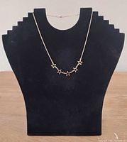 Necklace displayed on bust showing star charm arrangement