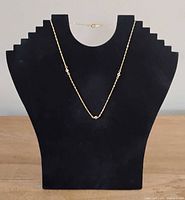 Necklace on display stand showing overall design and clasp