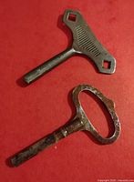 Top-down view of both metal clock keys on red background