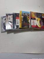 Stack of five sealed CDs showing spines and cover fronts