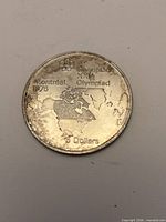 Reverse showing Olympic rings, map design and denomination