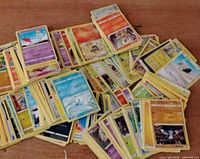 Overhead view of assorted face-up Pokémon cards scattered on table