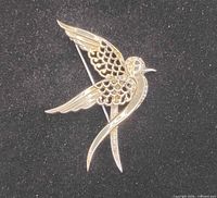 Front view of gold & silver dove brooch on black background