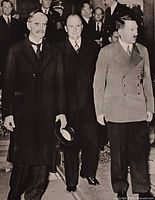 Front of vintage magazine page showing Chamberlain, unidentified official, and Hitler walking